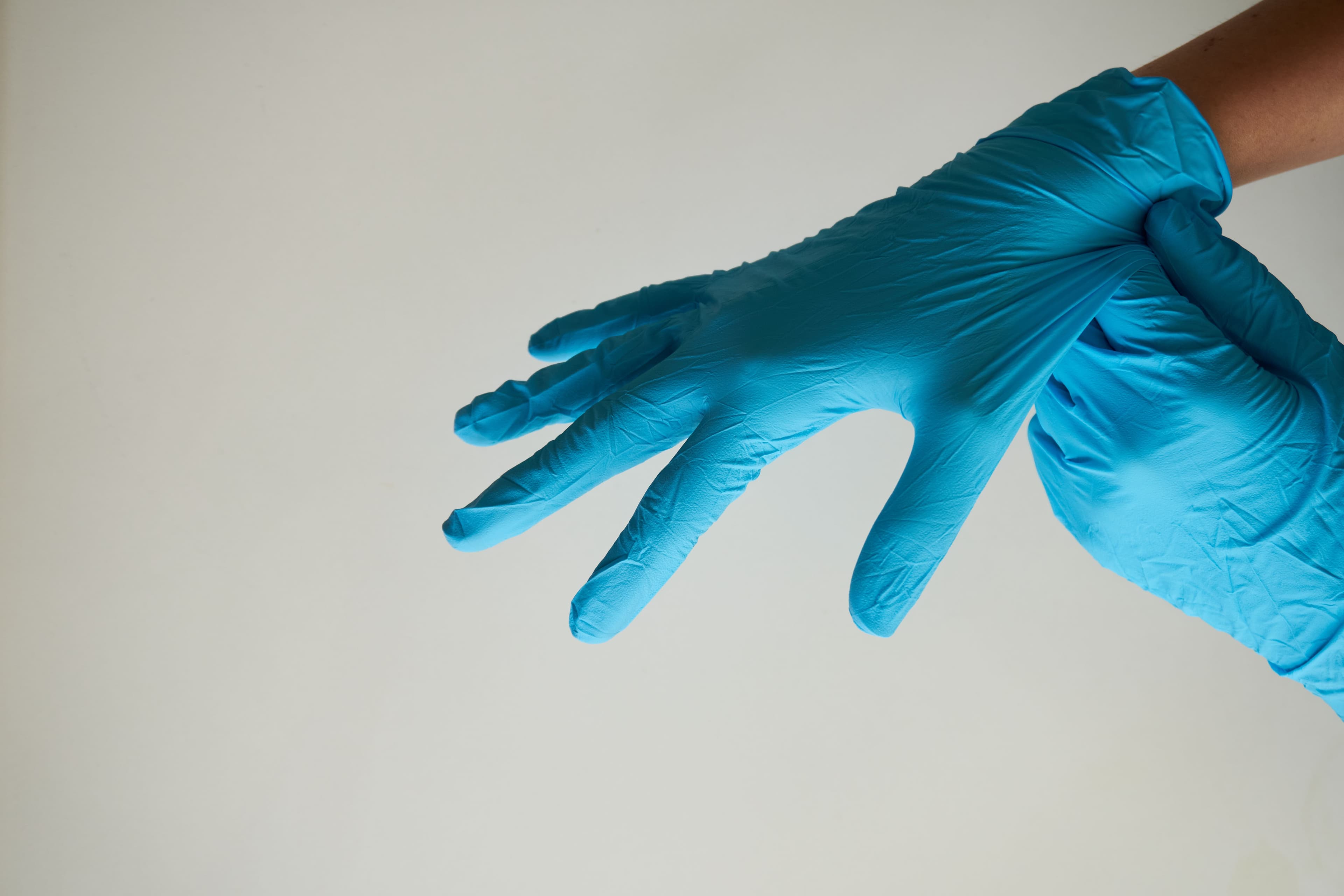 Blue disposable nitrile gloves being put on